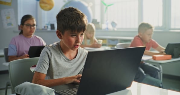 Boy using laptop in classroom